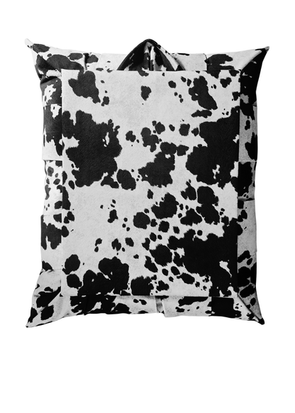 A back view of an overstuffed picture frame featuring a black and white cow print pattern, shown against a plain white background.